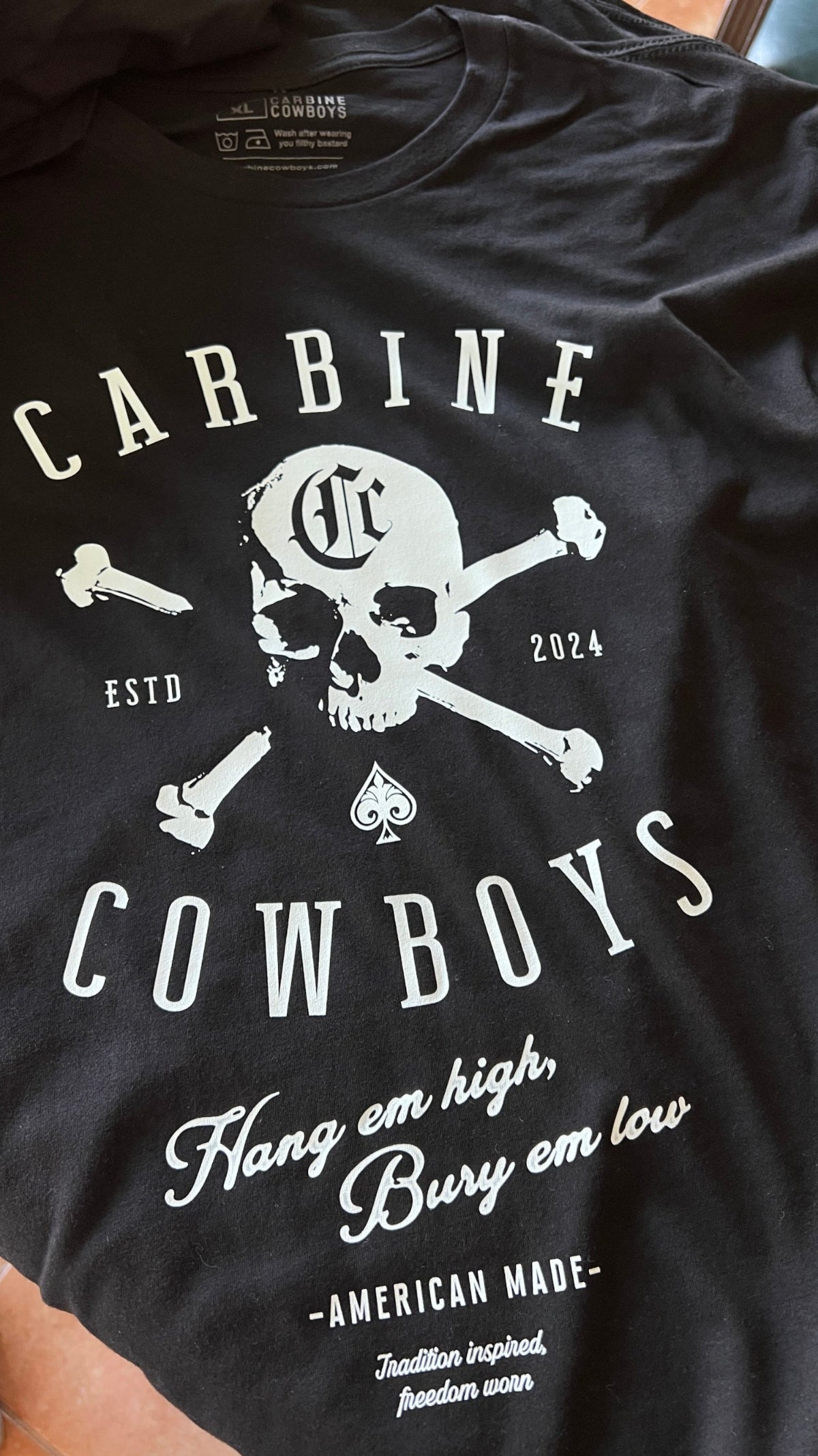 Black Carbine Cowboys Hang Em High tee front. American-Made, Tradition-Inspired, Freedom-Worn.