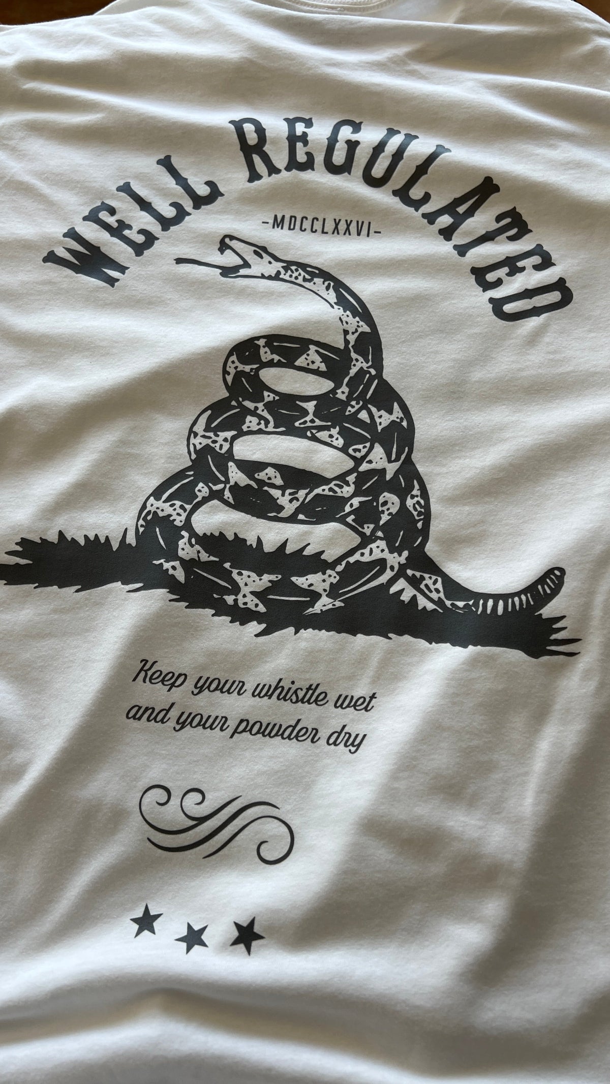 White Carbine Cowboys Well Regulated tee back. Keep your whistle wet and your powder dry.